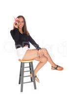 Beautiful woman sitting in shorts on chair.