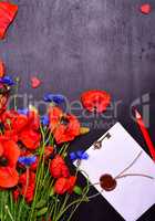 Red poppies and blue cornflowers with a sealed envelope