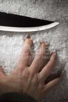 Hand and knife in the snow