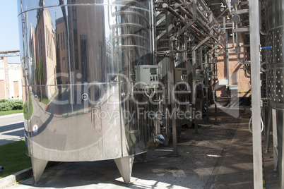 Metal chrome cask for wine photo. Stainless steel pipes and barrels as part of winery equipment