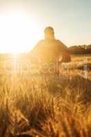 African woman in traditional clothes walking in a field of crops