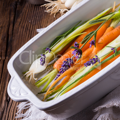 Young carrots and spring onions prepared for baking