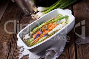 Young carrots and spring onions prepared for baking