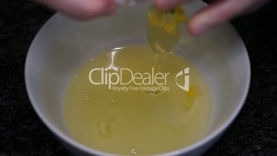 Slow motion of woman cracking egg inside bowl