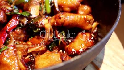 Motion of chicken with ginger and wine in casserole on table inside Chinese restaurant