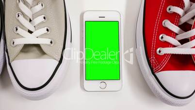 Motion of display shoes and green screen phone on white background for leisure concept