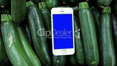 Motion of blue screen phone on zucchini background for cooking recipe concept