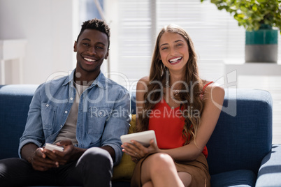 Male and female executives discussing over digital tablet in the office