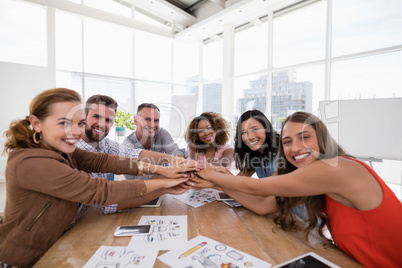 Team of executives forming hand stack in the office