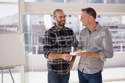 Happy colleagues discussing over digital tablet