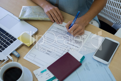 Female executive filling form at her desk