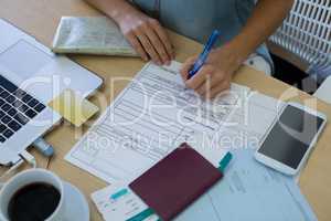 Female executive filling form at her desk