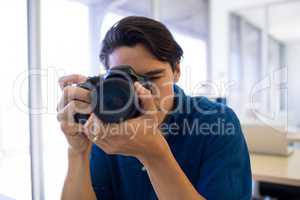 Male executive clicking a picture on digital camera