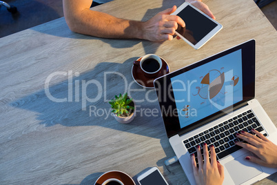 Executives using laptop and digital tablet during a meeting