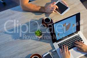 Executives using laptop and digital tablet during a meeting