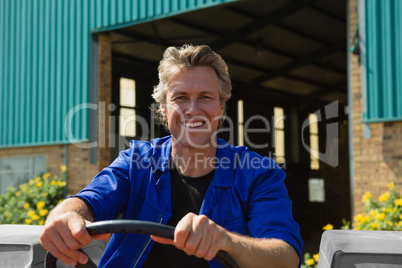 Smiling worker driving a tractor