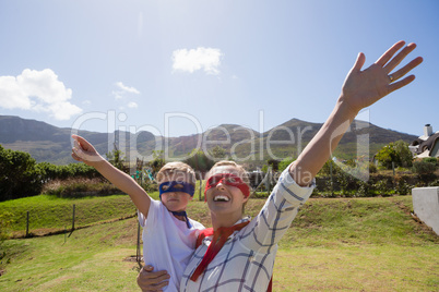 Mother and son pretending to be superhero in the backyard