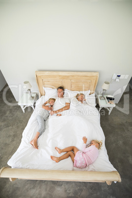 Family sleeping on bed in the bed room