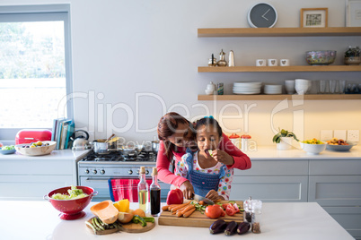 Mother and daughter chopping vegetables in kitchen