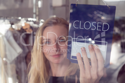 Shop worker with the open and closed sign