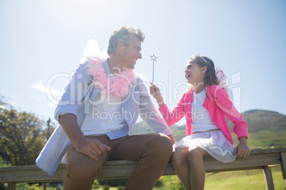 Daughter and father in fairy costume interacting with each other