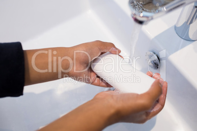 Girl washing hands in bathroom sink