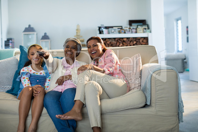 Smiling family watching television together in living room