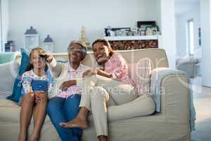 Smiling family watching television together in living room