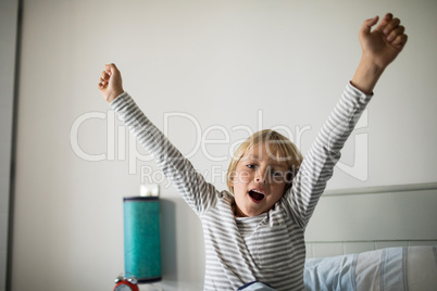 Boy yawning on bed in the bedroom at home