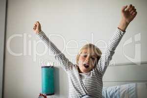 Boy yawning on bed in the bedroom at home