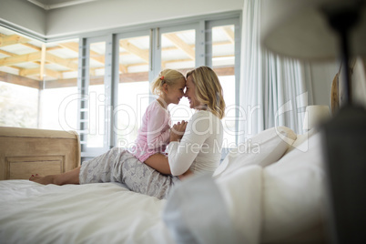 Mother and daughter having fun in the bedroom