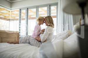 Mother and daughter having fun in the bedroom