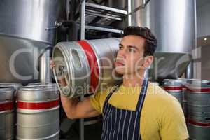 Worker looking away while carrying keg