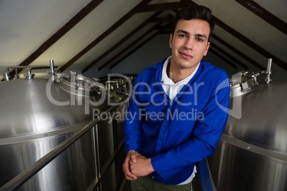 Portrait  of man standing amidst storage tanks