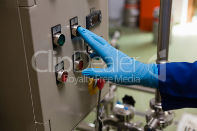 Cropped hand of worker pressing button of machinery