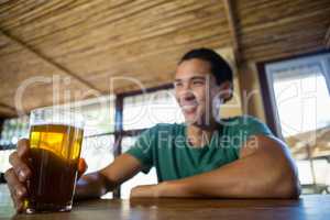 Smiling man with beer glass looking away