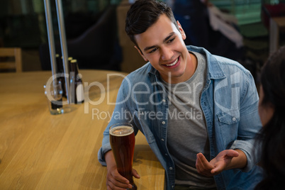 Smiling man talking to friend at bar