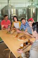 High angle view of bartender serving beer glass to friends