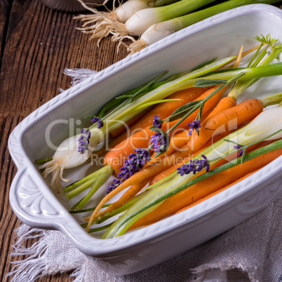 Young carrots and spring onions prepared for baking