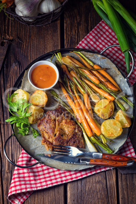 Grilled steak with vegetables and fried potatoes
