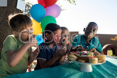 Happy children enjoying sweet food at park