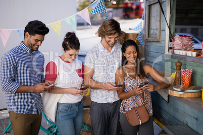 Friends using mobile phone at counter