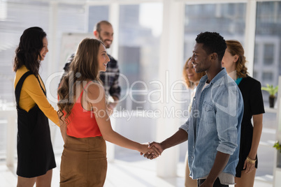 Happy colleagues shaking hands