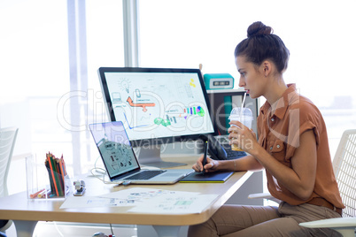 Female executive working over graphic tablet at her desk Female executive working over graphic tablet at her desk