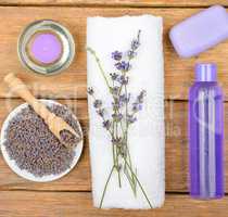 Cosmetics and an aromatic candle made from lavender flowers on a