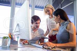 Executives discussing over digital tablet during a meeting