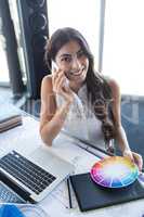Female executive talking on mobile phone at her desk