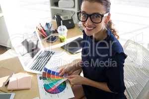 Female executives holding color shade swatch at her desk