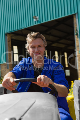 Smiling worker driving a tractor