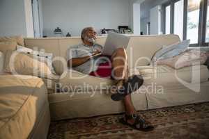 Senior man using laptop in the living room